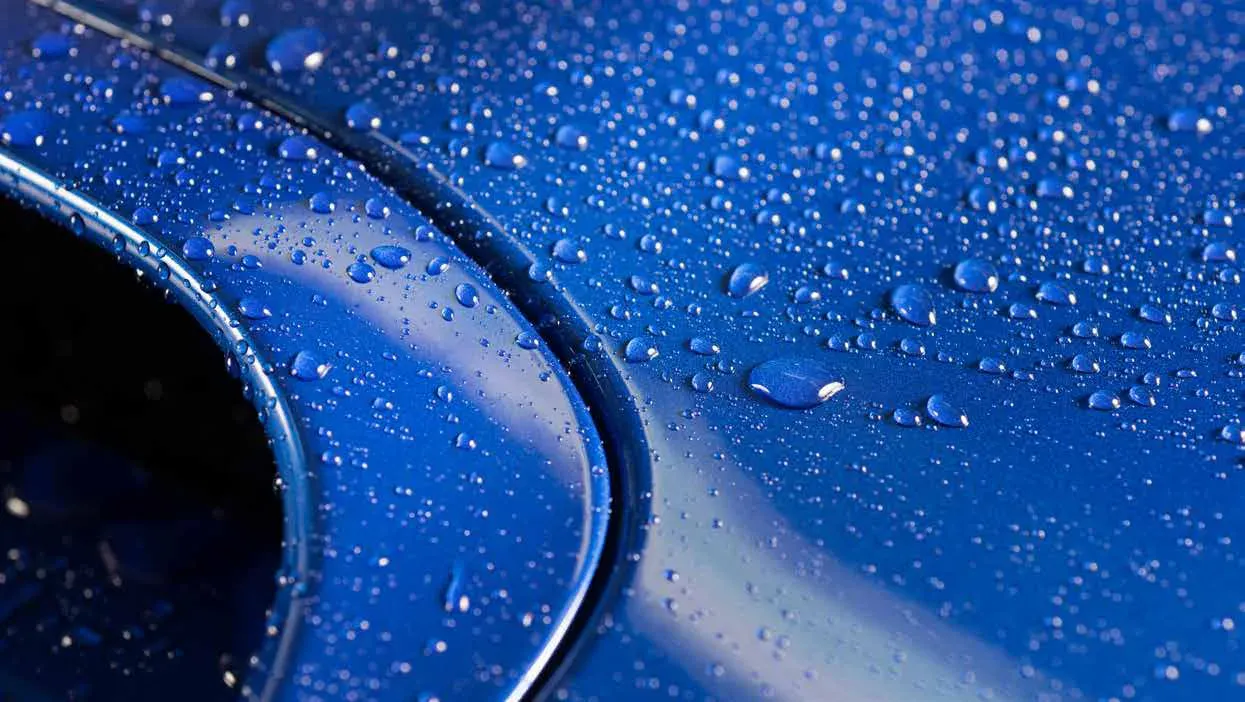 Gouttelettes d’eau sur une carrosserie bleue fraîchement peinte